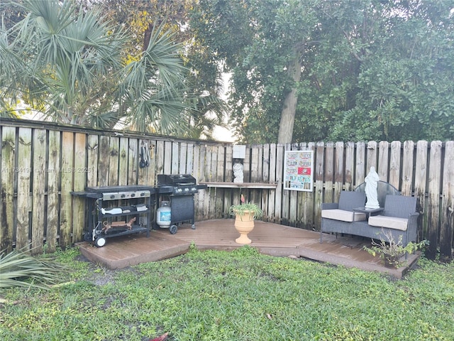 wooden terrace with a grill and a lawn