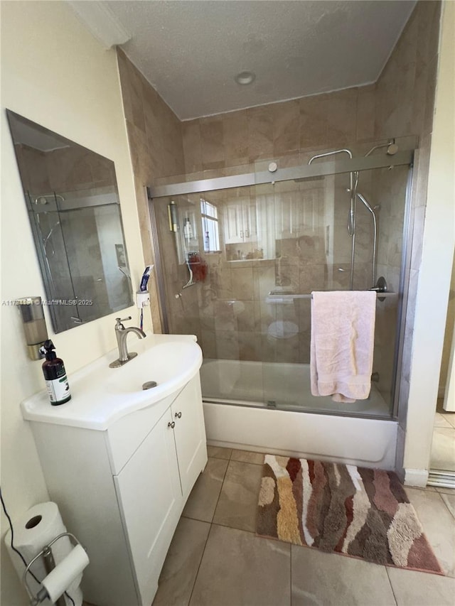 bathroom featuring tile patterned flooring, enclosed tub / shower combo, and vanity