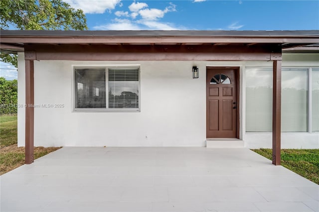 view of exterior entry featuring stucco siding