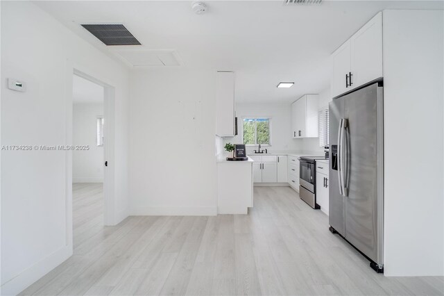 kitchen with stainless steel appliances, sink, white cabinets, and light hardwood / wood-style flooring