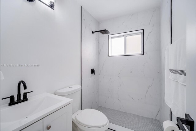 bathroom featuring tiled shower, vanity, and toilet