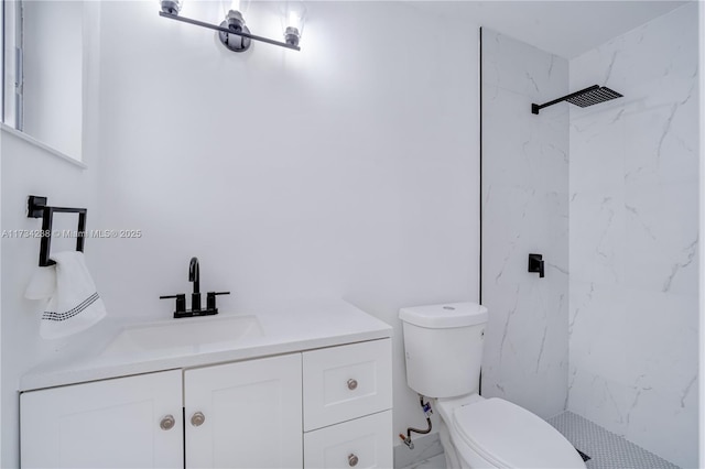 bathroom with vanity, toilet, and tiled shower