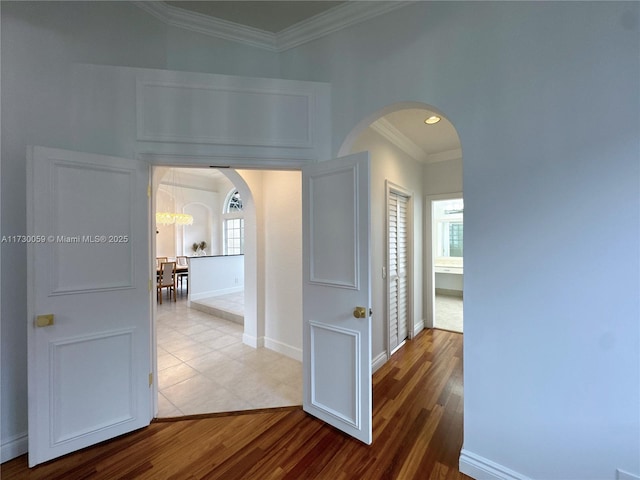 corridor with crown molding and hardwood / wood-style flooring