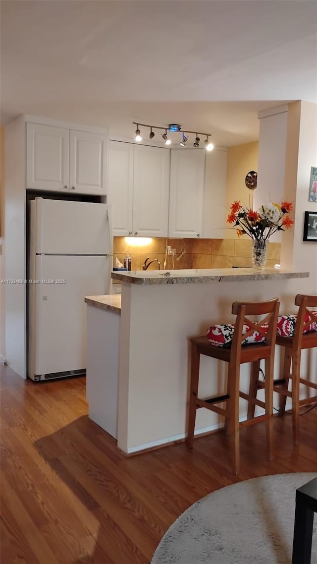 kitchen featuring light hardwood / wood-style floors, white cabinets, and white refrigerator