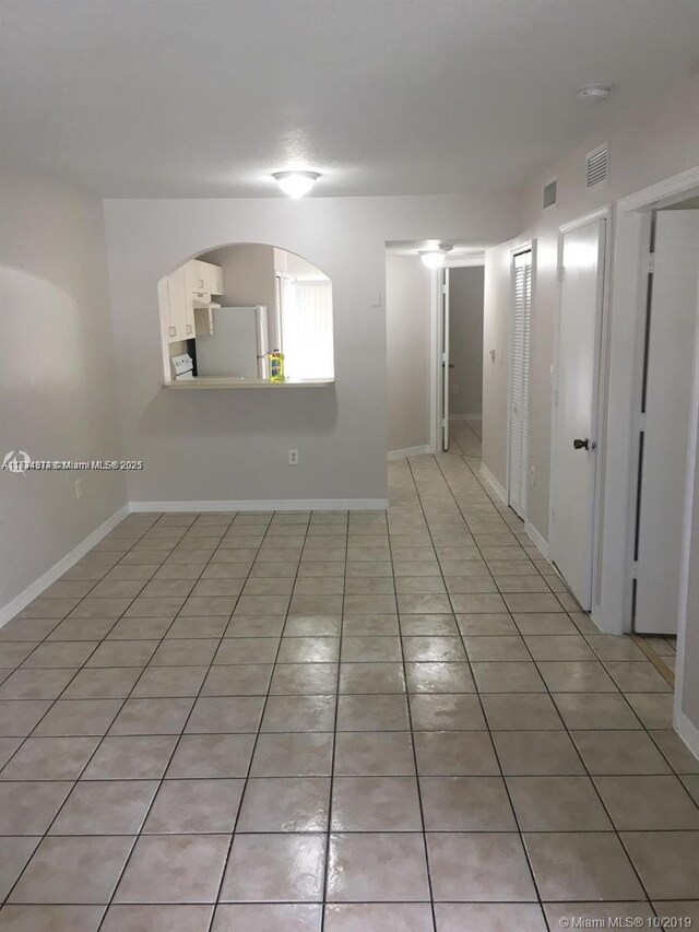 spare room featuring light tile patterned flooring