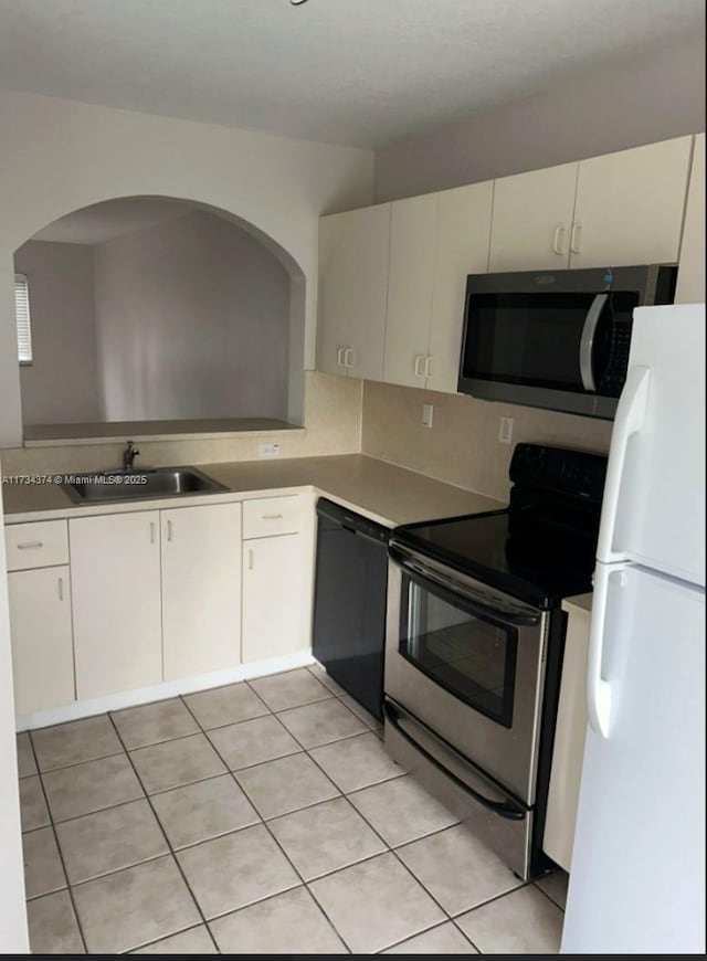 kitchen with sink, backsplash, appliances with stainless steel finishes, and light tile patterned flooring