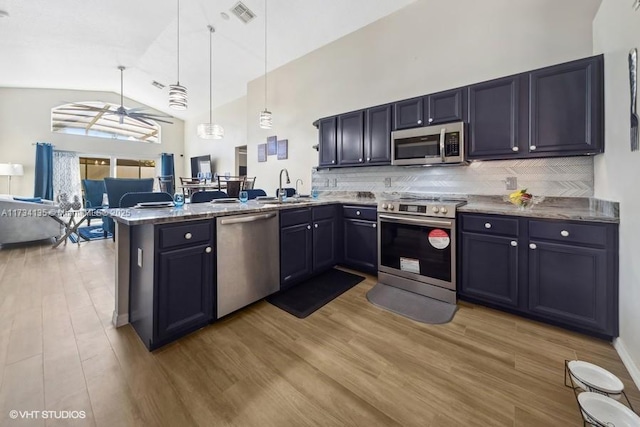 kitchen with visible vents, a sink, light wood-style floors, appliances with stainless steel finishes, and a peninsula