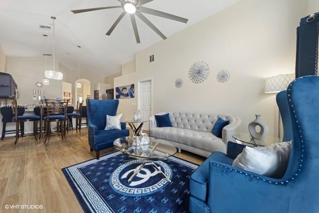 living room with high vaulted ceiling, wood finished floors, visible vents, and ceiling fan