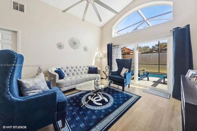 living room featuring high vaulted ceiling, light hardwood / wood-style floors, and ceiling fan