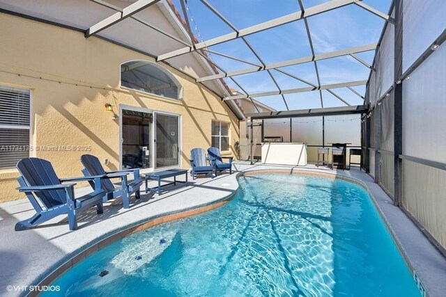 view of pool with a patio and glass enclosure