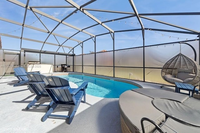 pool featuring glass enclosure and a patio area