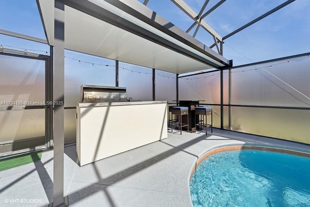 outdoor pool featuring glass enclosure, a patio, an outdoor kitchen, and outdoor dry bar