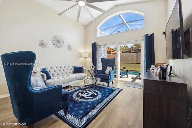 living room featuring vaulted ceiling, ceiling fan, and light wood-type flooring