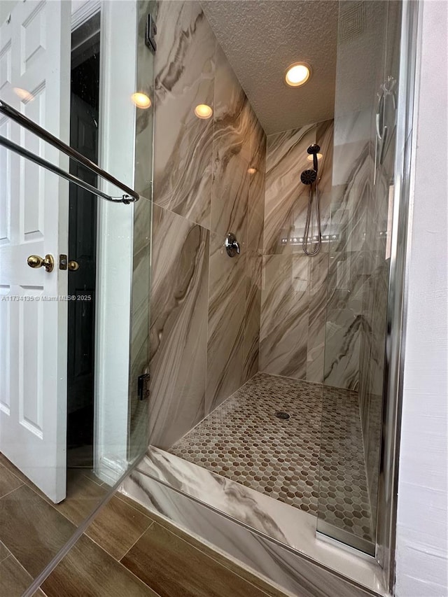 bathroom featuring a tile shower and a textured ceiling