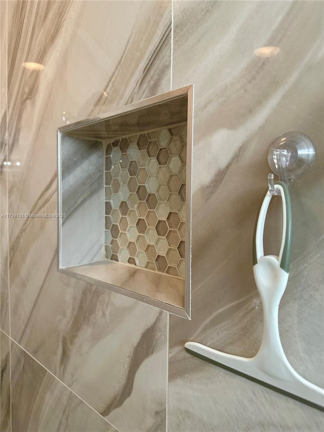 interior details featuring tiled shower