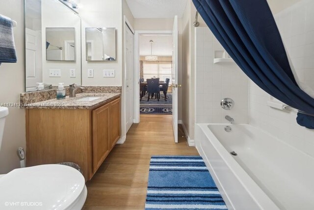 full bathroom with hardwood / wood-style flooring, vanity, toilet, and shower / bath combo with shower curtain