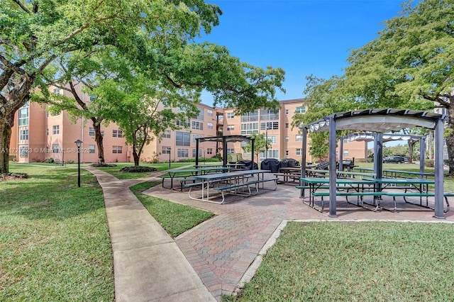 view of community featuring a yard and a pergola