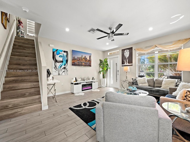 living room with light hardwood / wood-style floors and ceiling fan