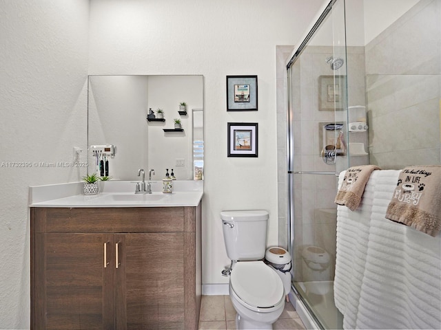 bathroom featuring an enclosed shower, vanity, tile patterned floors, and toilet