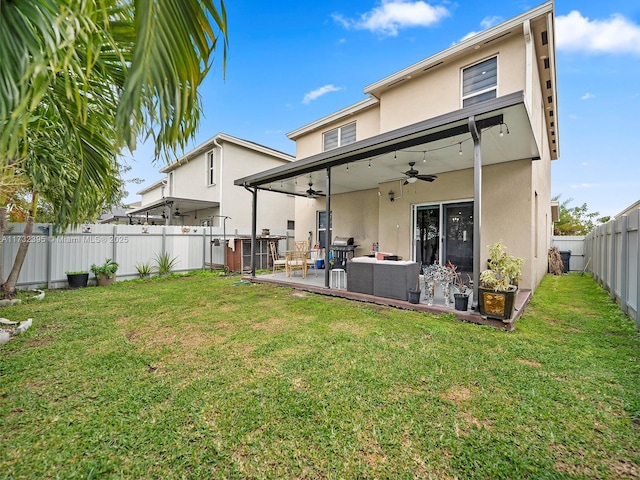 back of house featuring an outdoor living space, a patio, a yard, and ceiling fan