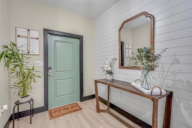 foyer featuring light hardwood / wood-style floors and wood walls