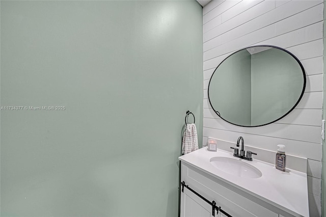 bathroom featuring vanity and wood walls