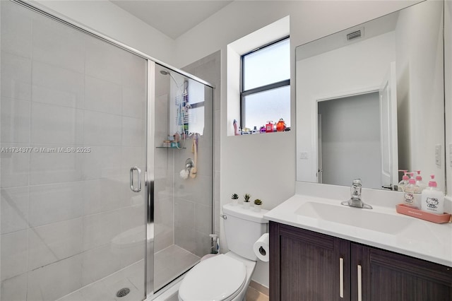 bathroom with vanity, a shower with shower door, and toilet