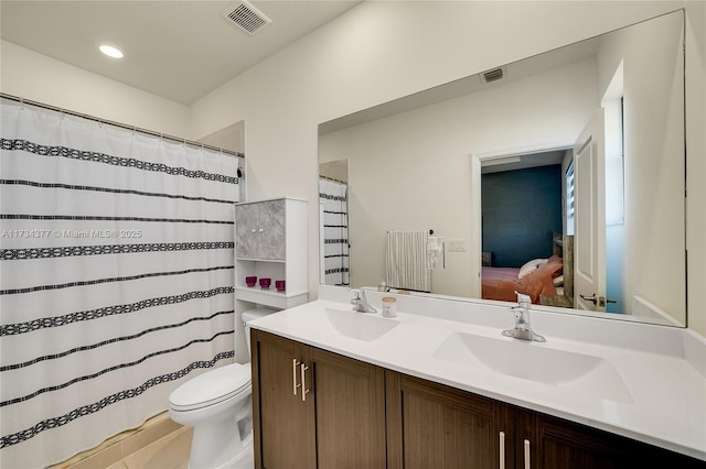 bathroom featuring vanity, toilet, and tile patterned flooring