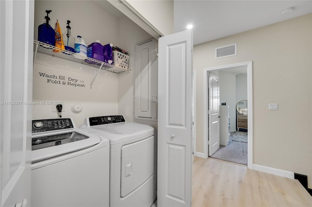 laundry room with separate washer and dryer and light hardwood / wood-style flooring