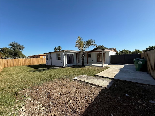 rear view of house with a patio area and a lawn