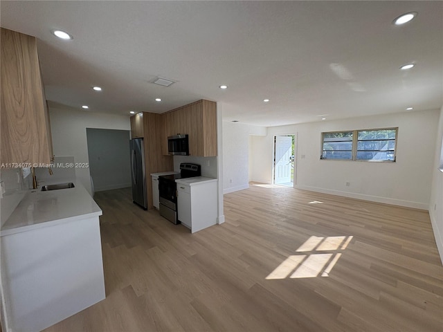 kitchen featuring stainless steel appliances, sink, and light wood-type flooring