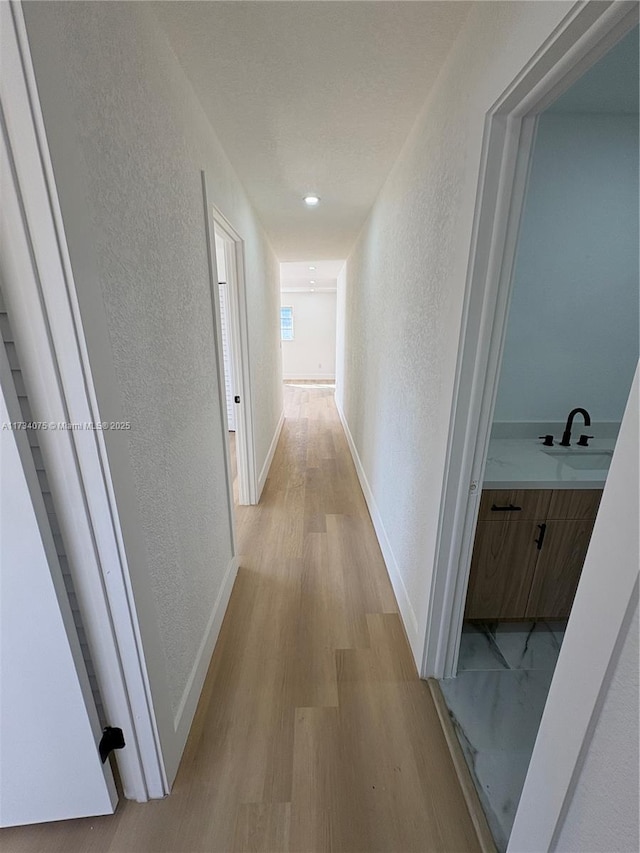 hall with sink and light hardwood / wood-style flooring