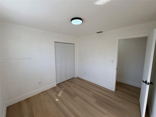 unfurnished bedroom featuring a closet and light wood-type flooring