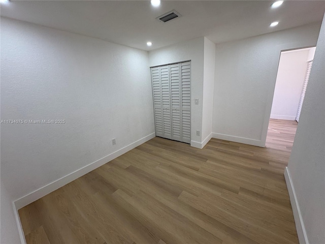 unfurnished bedroom with hardwood / wood-style flooring and a closet