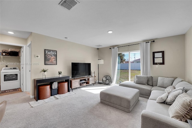 living room featuring washer / clothes dryer and light carpet