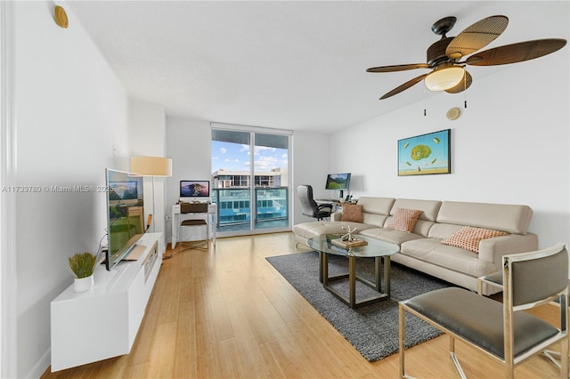 living room featuring floor to ceiling windows, ceiling fan, and light wood-type flooring