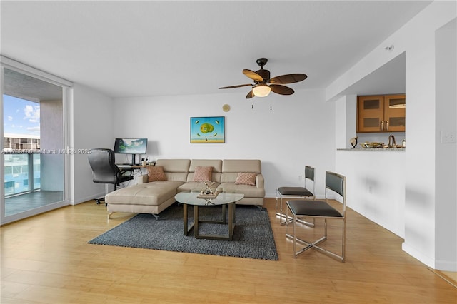 living room featuring light hardwood / wood-style floors, floor to ceiling windows, and ceiling fan