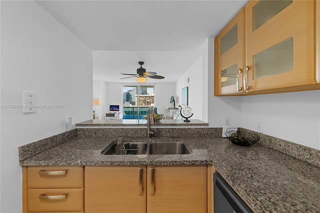 kitchen with sink, dark stone countertops, and ceiling fan