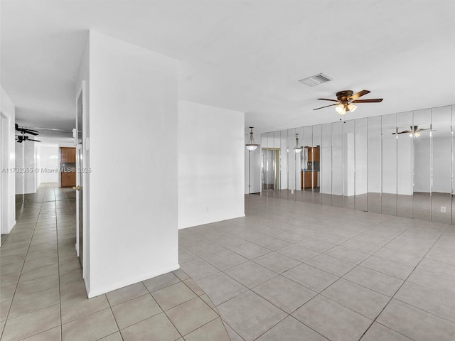 tiled empty room featuring ceiling fan