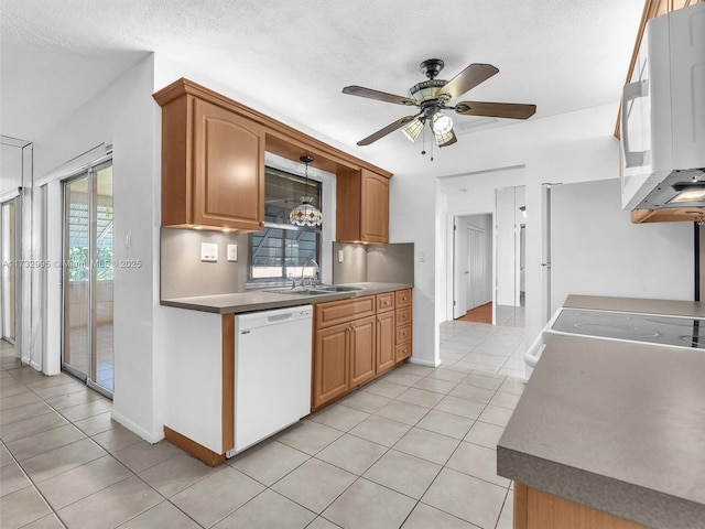 kitchen featuring sink, hanging light fixtures, white appliances, and light tile patterned floors