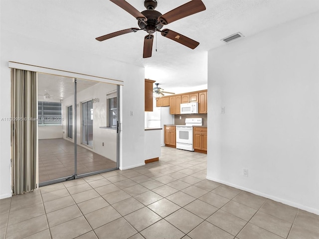 unfurnished living room featuring light tile patterned floors and ceiling fan