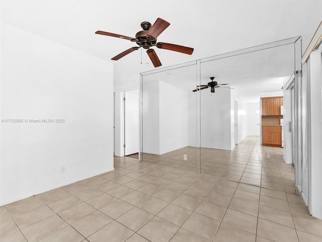 tiled empty room featuring ceiling fan