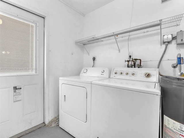 clothes washing area with washer and clothes dryer and water heater