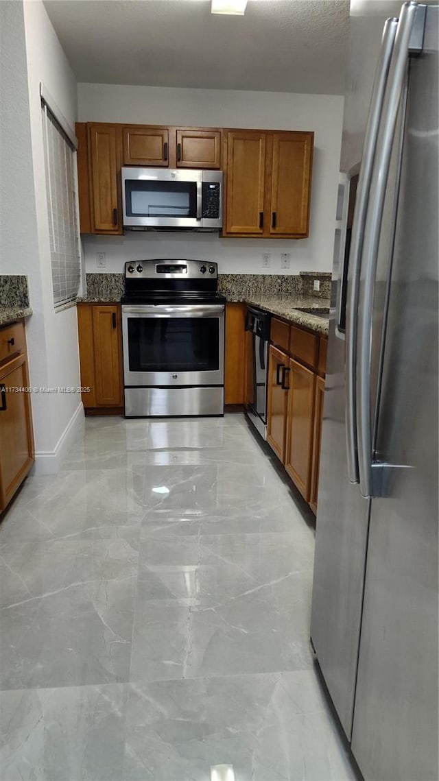 kitchen featuring stainless steel appliances and dark stone counters