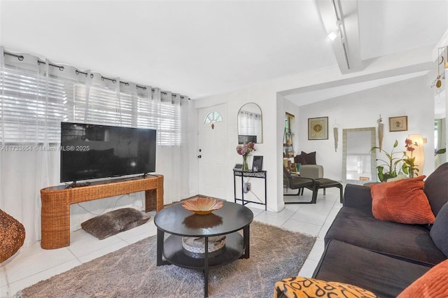 living room with light tile patterned flooring and vaulted ceiling with beams