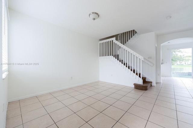 2818 SE 16th Ave Unit 118, Homestead, FL 33035 - unfurnished room with arched walkways, light tile patterned flooring, and stairs