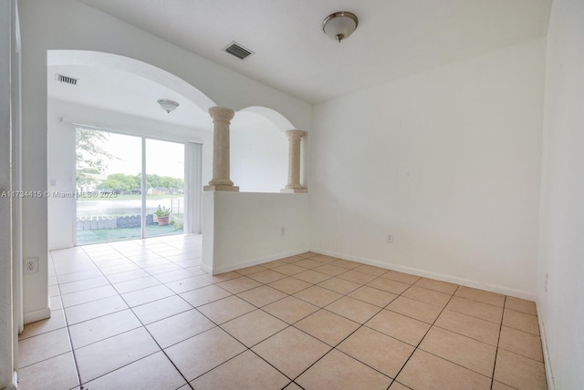 2818 SE 16th Ave Unit 118, Homestead, FL 33035 - empty room featuring light tile patterned floors, ornate columns, and arched walkways