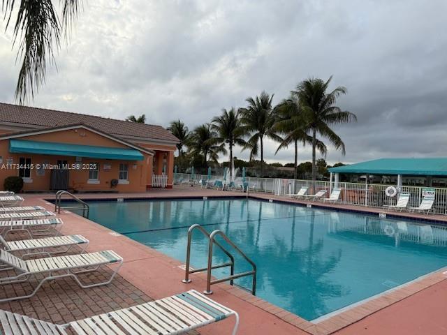 pool featuring fence and a patio