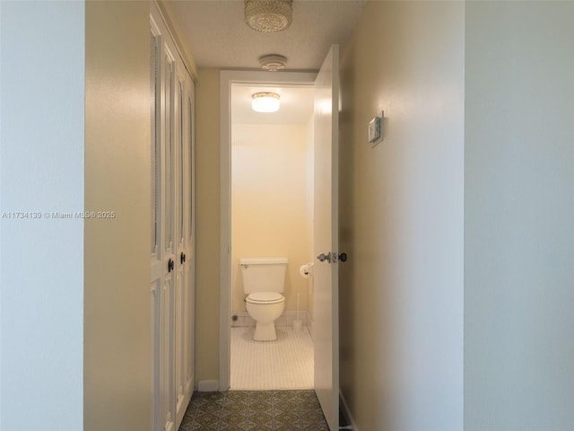 hallway with dark tile patterned floors