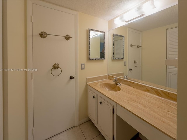 bathroom with vanity, tile patterned flooring, and a textured ceiling